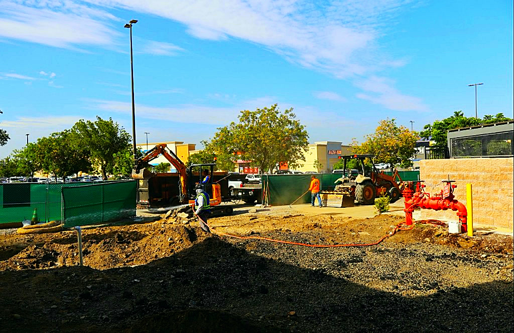Active commercial earthwork site with equipment and crew