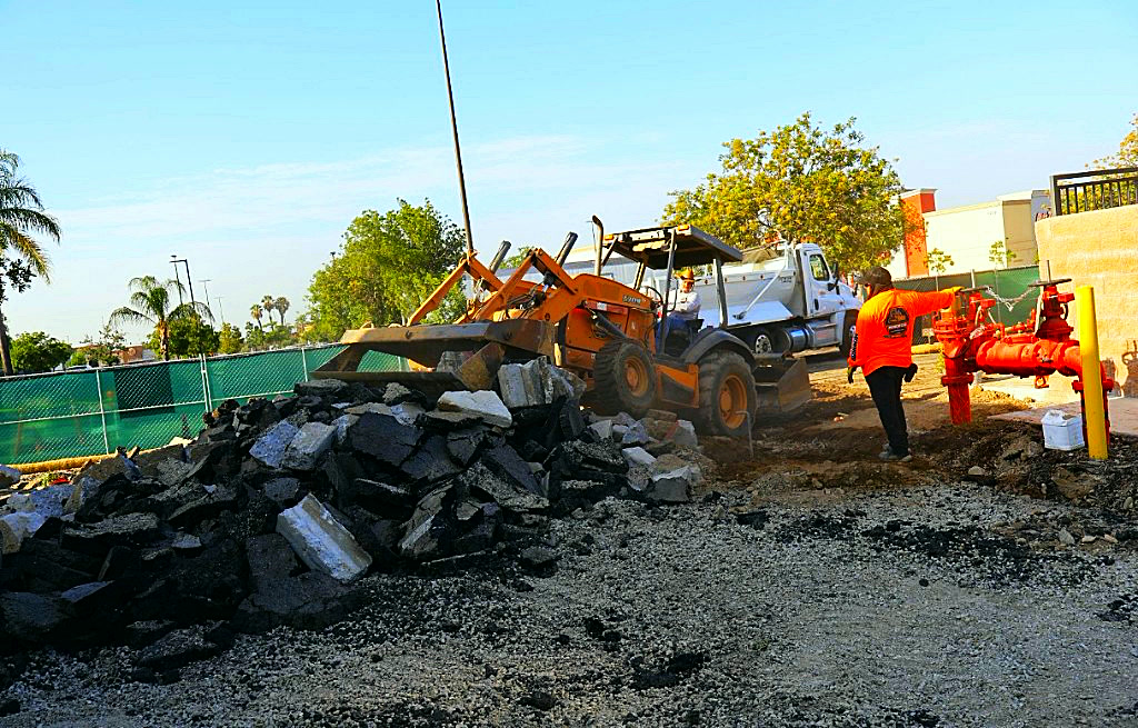 Loader working asphalt demo debris on an active site