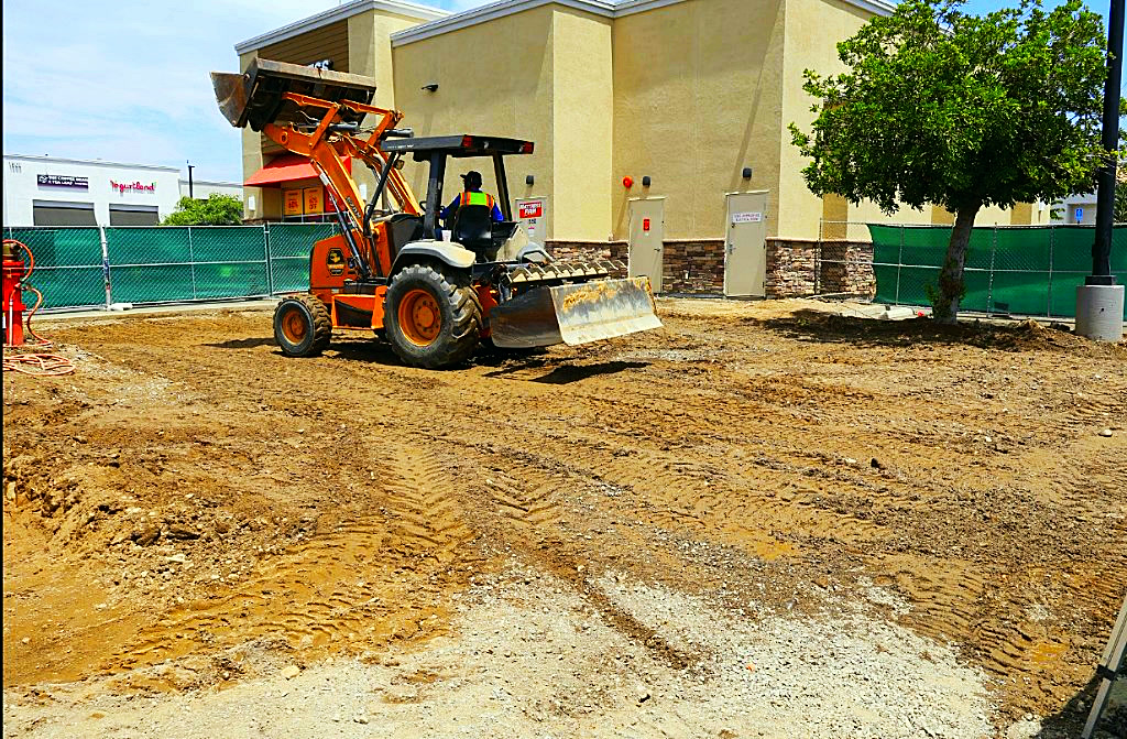 Skip loader rough grading the work area