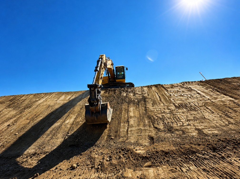 Excavator completing precision slope grading